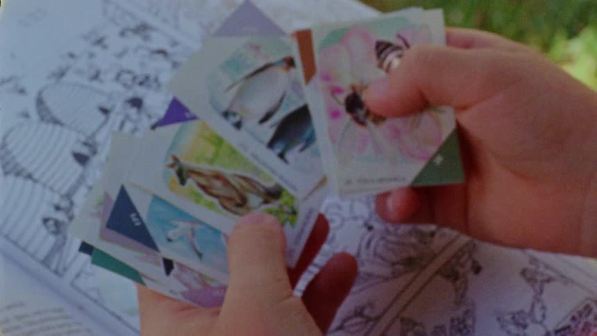 A human hand exchanging stickers above a book