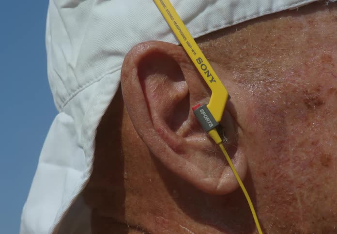 An old man with yellow wired earphones