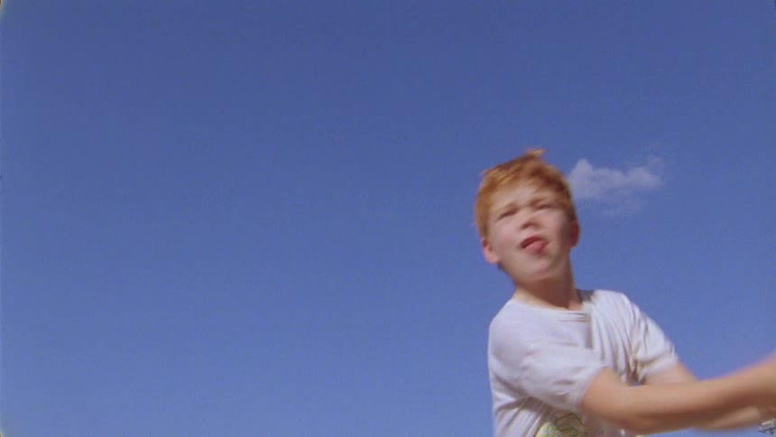 A boy hit the tennis ball with the racket in day time