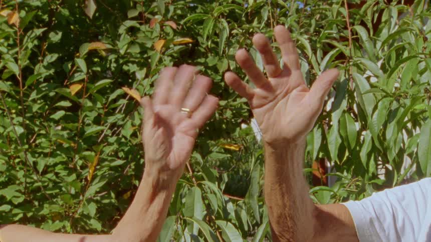 Closeup of two different elderly peoples hands waving goodbye
