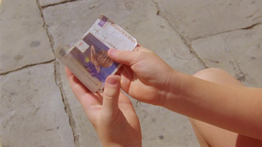 A child holds banknotes of foreign currency in his hands