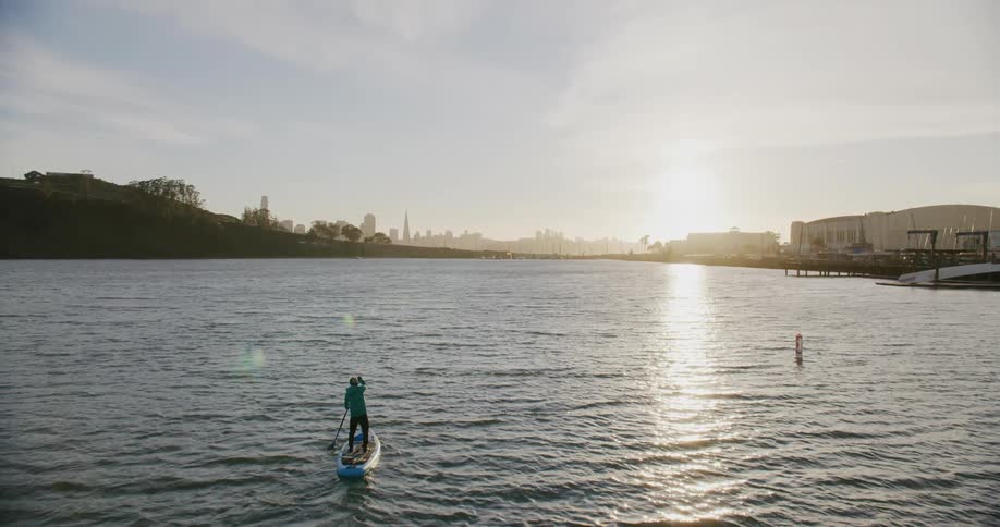 Person doing standup paddle on the San Francisco Bay at sunset