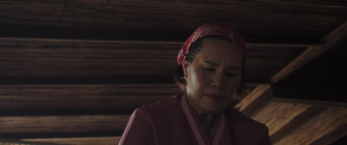 Portrait of a woman with a cloth on her head in a wooden indoor environment