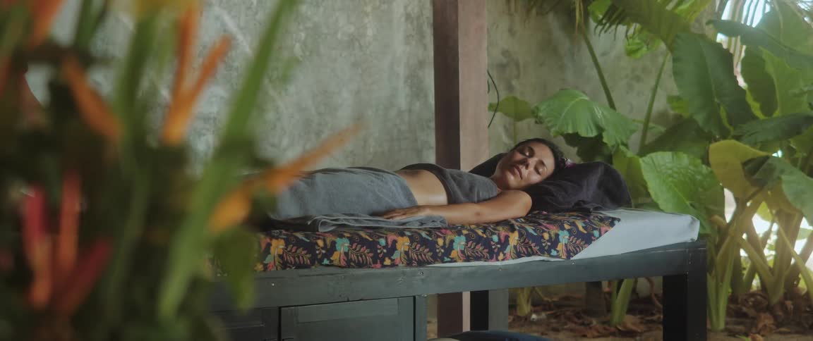 A woman lying down receives a relaxing massage