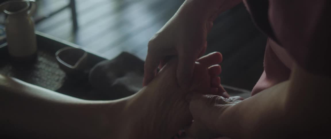 The masseur gently massages the foot