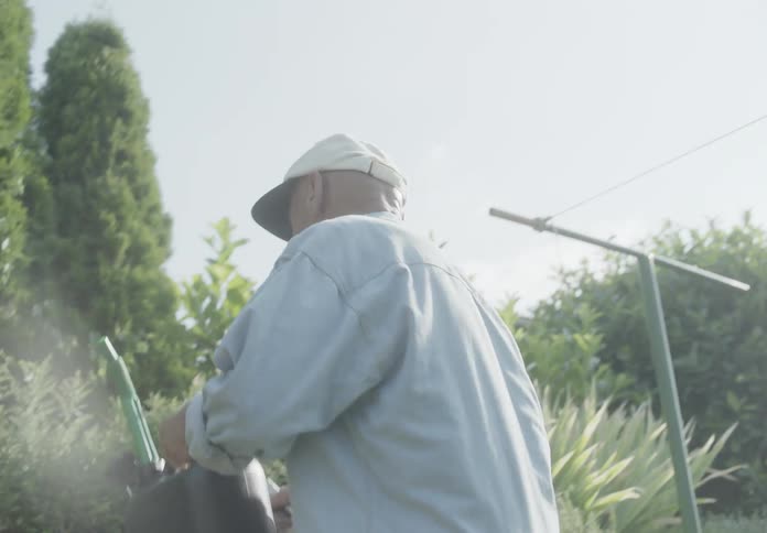 Man puts gas can on nearby wall after working with lawnmower