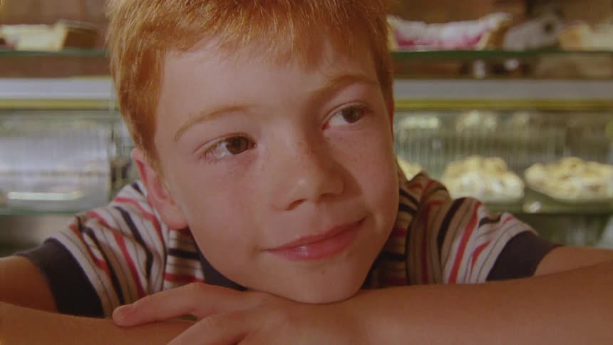 Boy with red hair and t shirt smiles happily