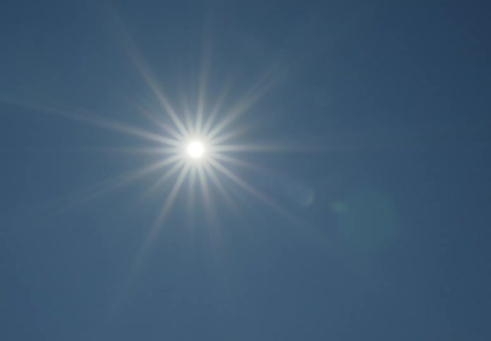 Aerial of the sun beaming in the clear blue sky