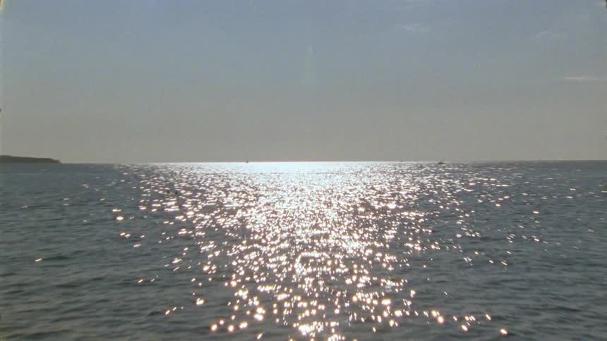 A horizon view of the ocean where sunlight shines on the water