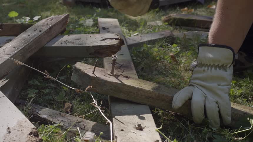 A person hammers a nail into the board