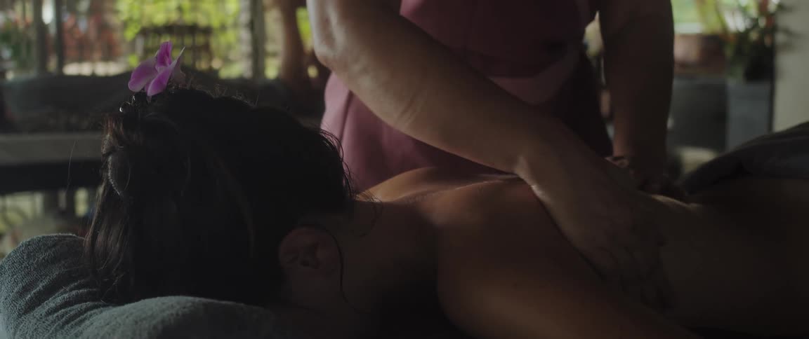 Woman massaging the back of a lady indoor during the day