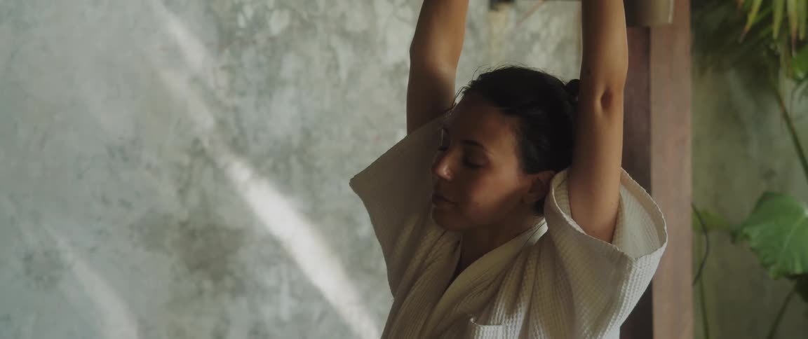 A woman practicing yoga in an environment with plants