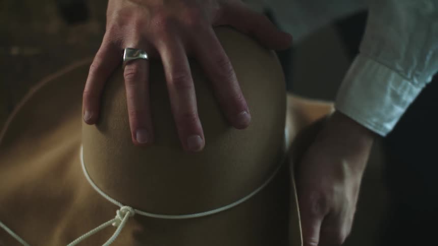 A person is making a cowboy hat