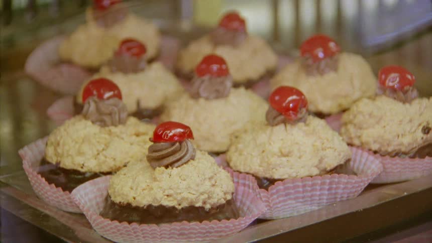 A tray with scones and cherries on a table