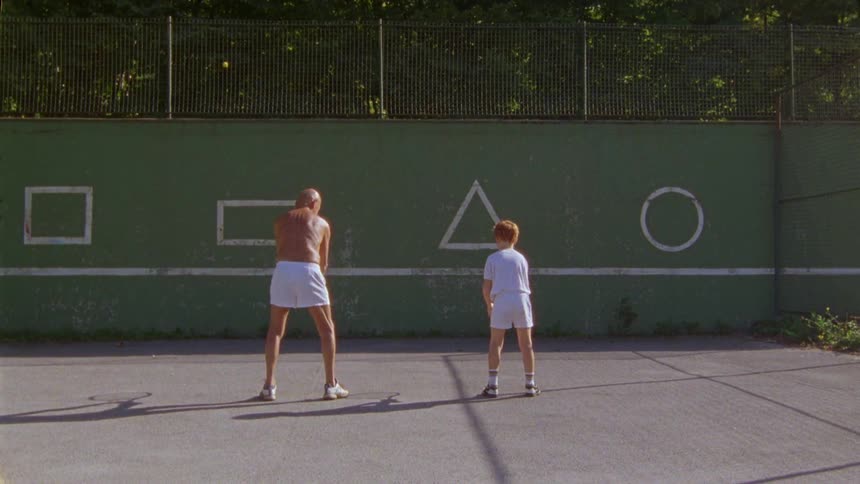 Elderly person and child practicing tennis together on a court