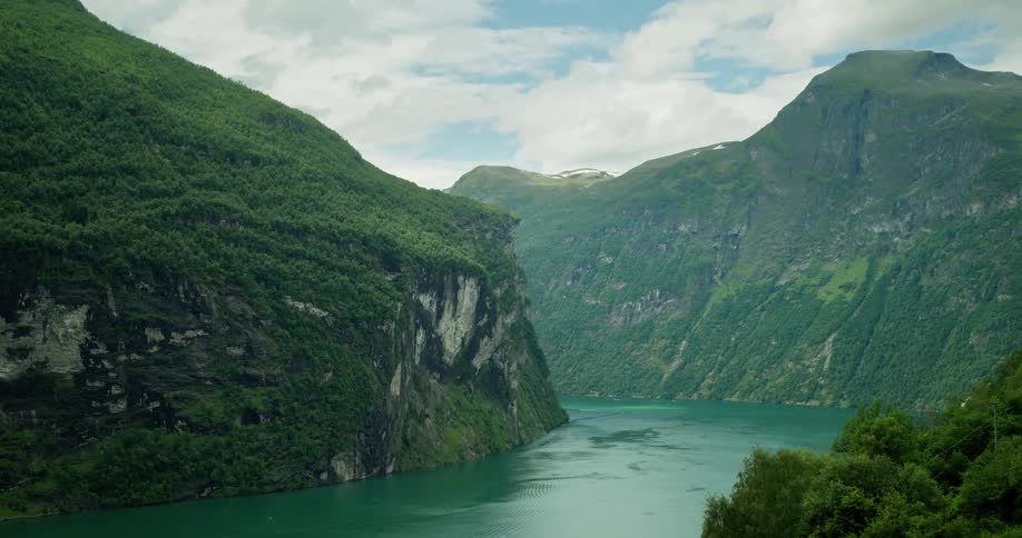 Aerial of the ocean surrounded by lush green mountains