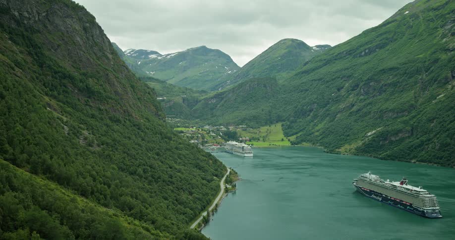 Horizon with mountain ranges and a blue lake in the middle with moving cruises