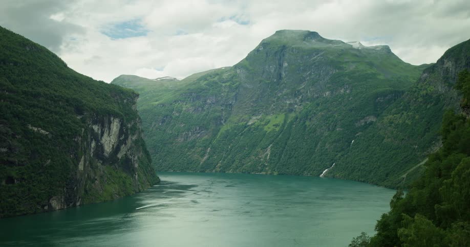 A landscape of a huge river flowing through forested mountains
