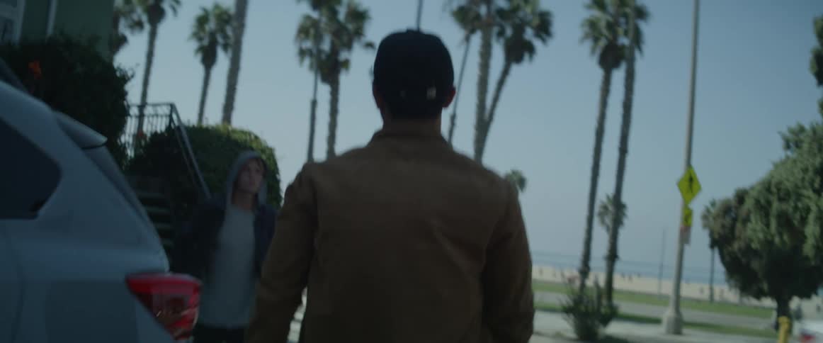 A man getting out of a car and going to hug another man who is waiting for him