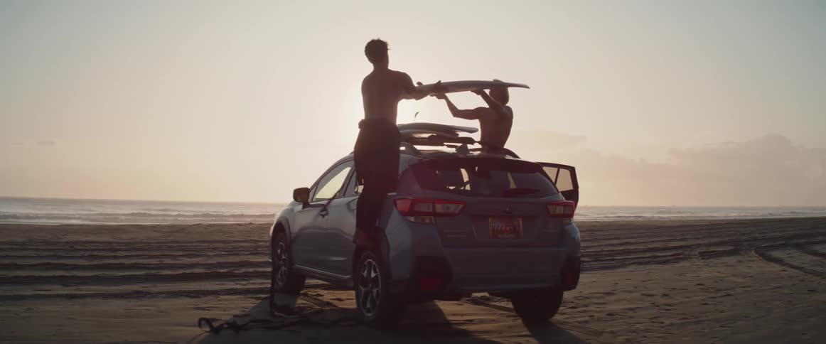 Surfers letting go of surfboards stuck in the car