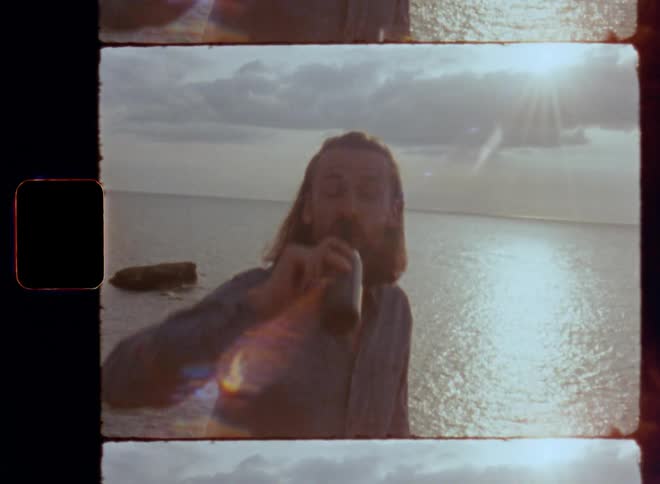 First person POV perspective shot of two friends clinking beer bottles and saying cheers while toasting and enjoying the happy life and quality leisure time by the sea on sunny day with great summer weather vibes and relaxed atmosphere