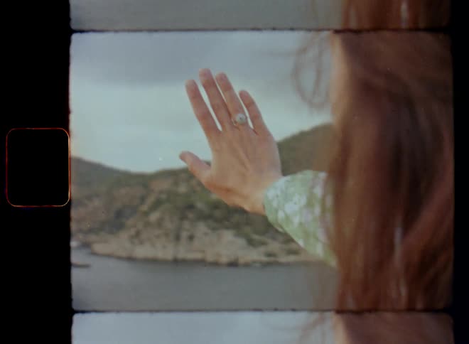 A proud woman puts her hand forward towards the horizon at the coast to present her silver diamond engagement ring after her boyfriend proposed on their anniversary who touches her shoulder in a loving and romantic way on Valentine’s Day