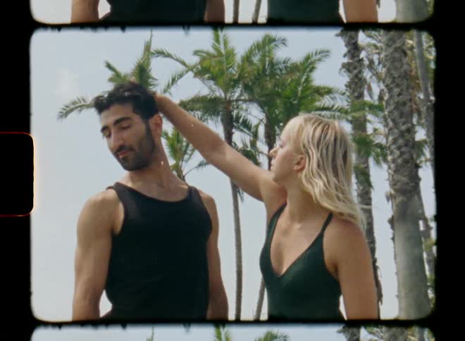 Man and woman facing each other dancing with body and arm movements in an outdoor environment