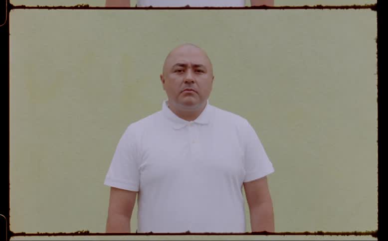 A man is posing in a white shirt