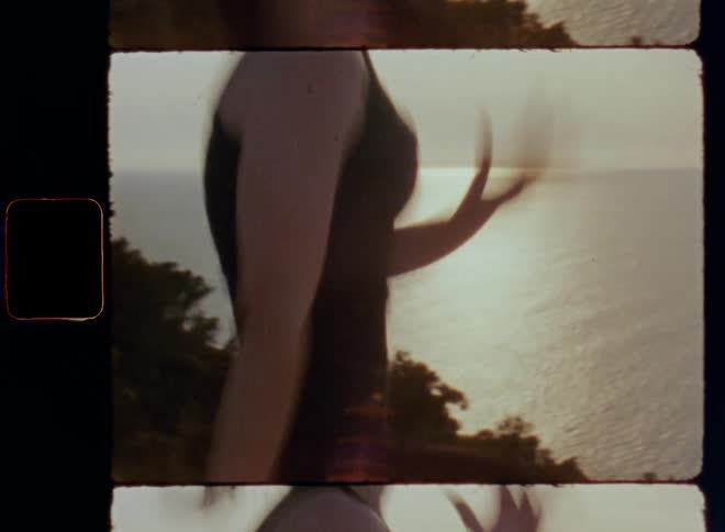 Dynamic handheld 8mm film of young woman working out on cliff next to the ocean at sunset doing skippings while running in place with high knees and fast arm movement to gain speed and fitness an increase health and well-being through leisure activity