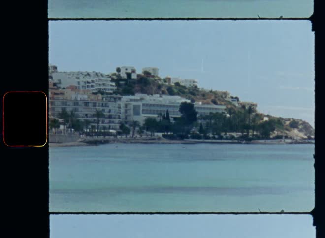 A touristic bay with sandy beaches and holiday apartments or flats and hotel buildings located at the sea or ocean with blue saltwater on a warm summer holiday day with sun shine and palm trees for a nice vacation destination for the tourism business