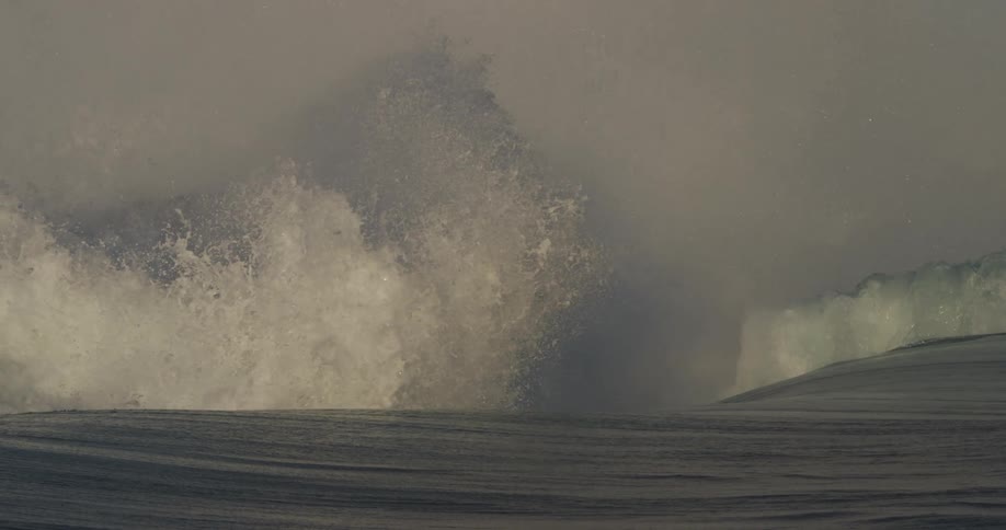 Large waves crash sending white water into the air