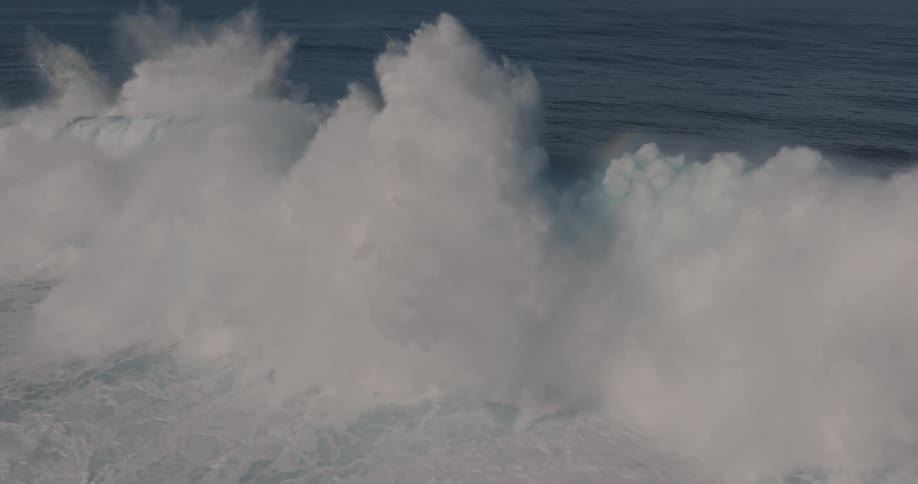 A huge wave crashing into the sea and lifting water upwards