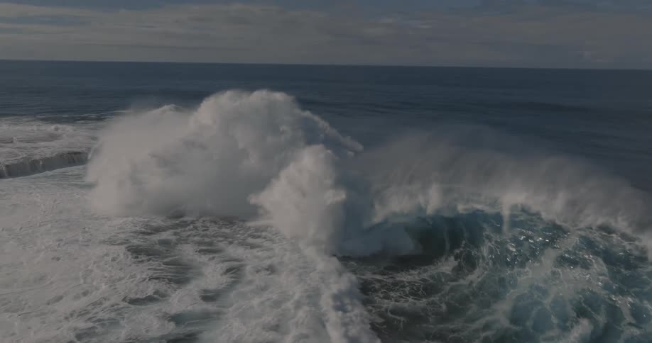 Aerial of the wide open ocean with large waves crashing over the surface