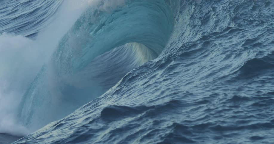 A large wave crashes in the ocean