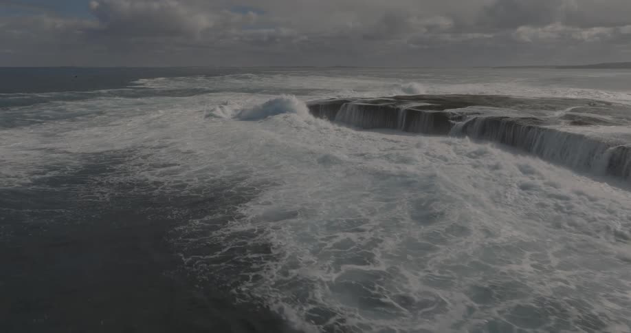 Aerial of sea waves moving in the water on a cloudy day