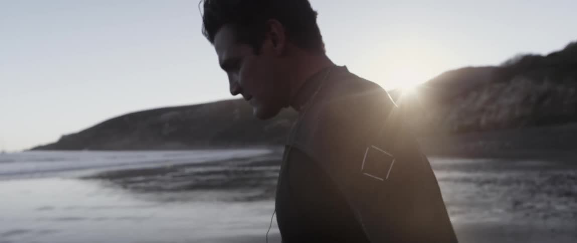 A man walks on the beach towards the water