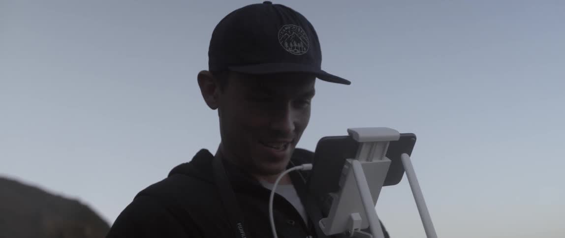 A man looks at a phone that is plugged in
