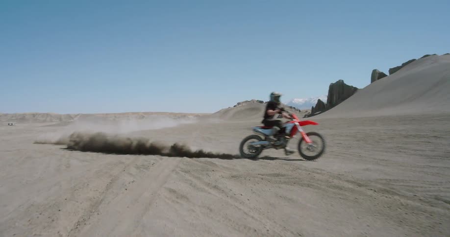 A person practicing motocross in the desert