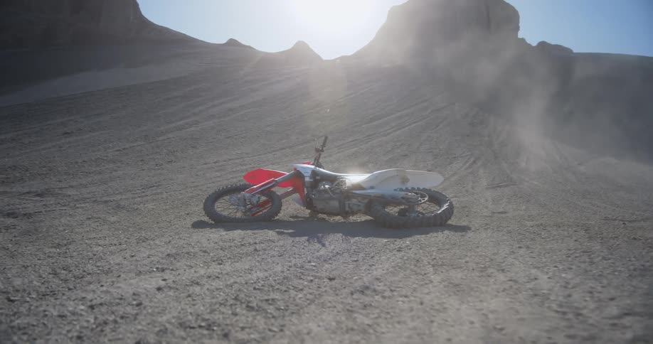 Motocross motorcycle stranded on the ground in the midst of the desert