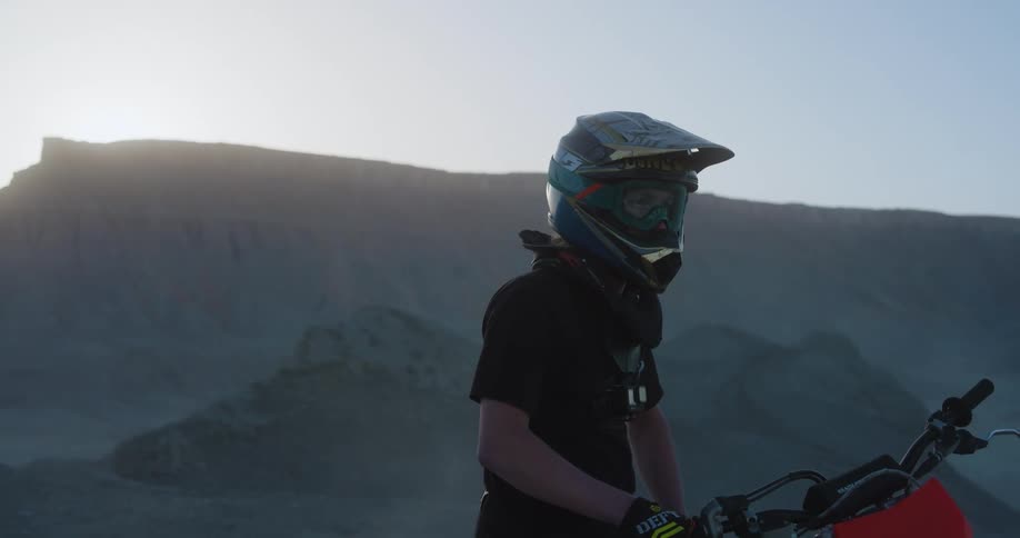 A man is parked on his dirt bike in the desert