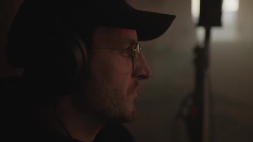 A man wearing large headphones nodding along to what hes hearing