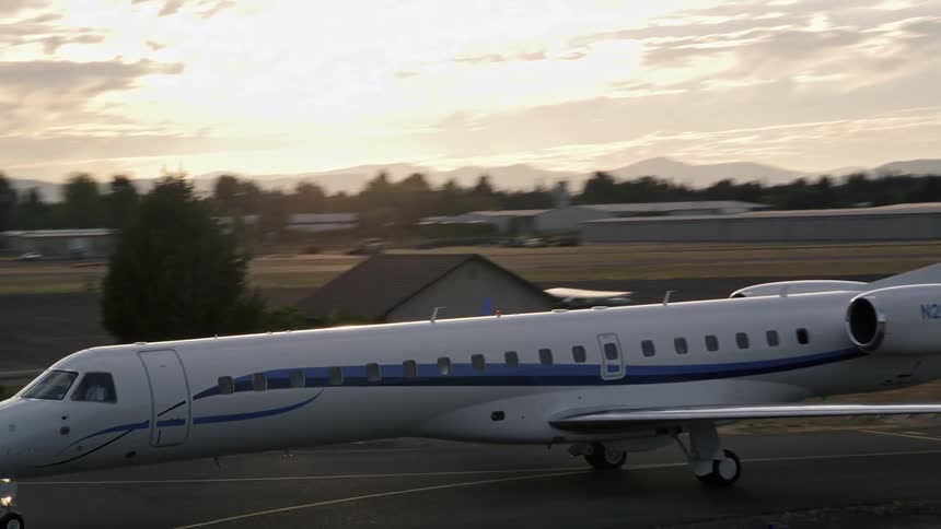 Aerial footage of a jet taxiing and ascending over Hillsboro Airport in Oregon during sunset