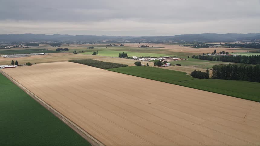  aerial footage of farmlands and rural area in Hillsboro Oregon approaching a farm on a cloudy day during summer