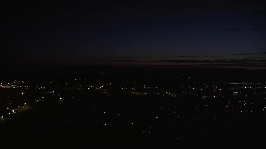 Approaching Hillsboro Airport in Hillsboro Oregon during the night with partly cloudy skies and a captivating view of the illuminated city below