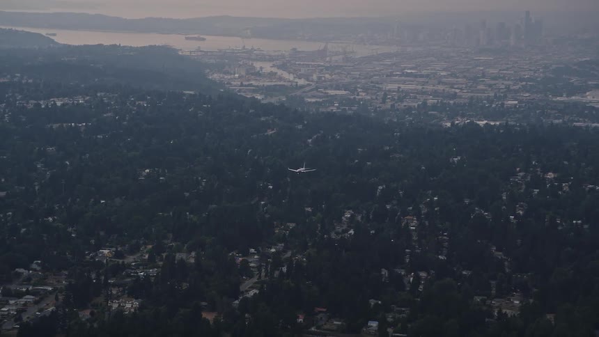 Aerial footage tracking an airliner near Seattle Tacoma International Airport showcasing the picturesque cityscape of Seattle Washington during the summer