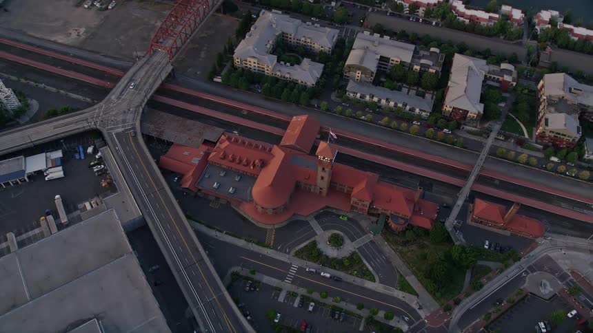 Bird's eye view of Union Station in Downtown Portland Oregon as trains pass by during sunset