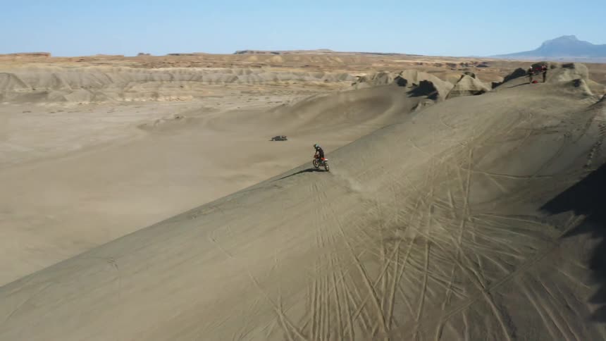 Aerial view of a person performing motocross in an open and desert environment