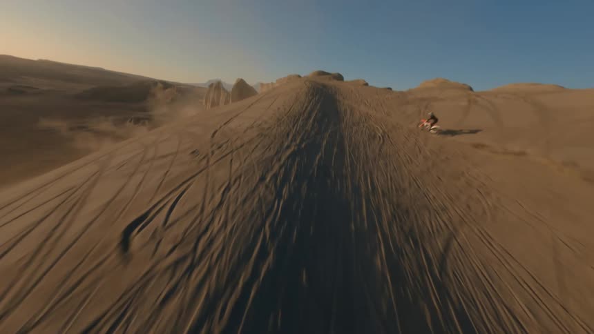 A person performing a motocross jump in the middle of the desert
