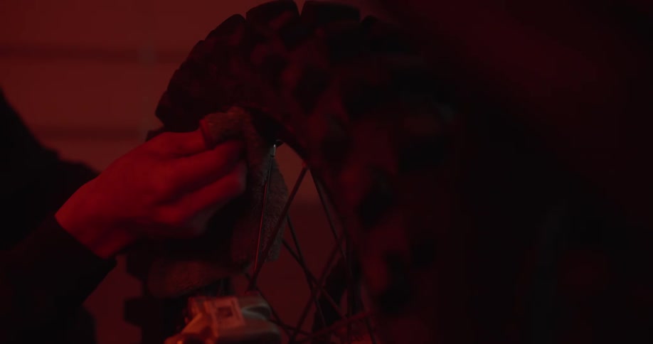 A person is cleaning a mountain bike tire rim inside