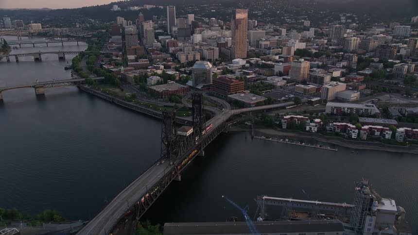 an aerial view of downtown Portland Oregon during a stunning summer sunset showcasing the vibrant city river bridges busy with cars highrises and skyscrapers
